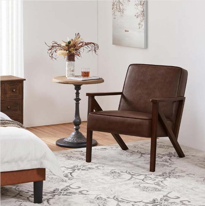 Brown faux leather accent chair with wooden armrests in a living room